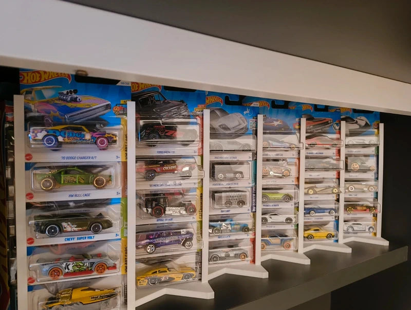 Vista frontal de una colección de coches a escala 1:64 organizada en expositores blancos